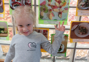 dziewczynka pokazuje swoje zdjęcie z przekąskami owocowymi